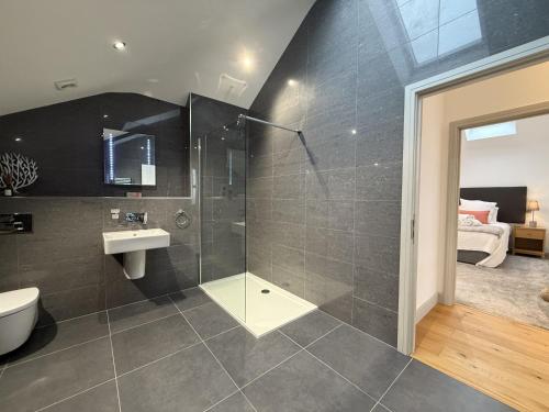 a bathroom with a shower and a toilet and a sink at Fishers View, Castle Approach, Tregenna Castle in St Ives