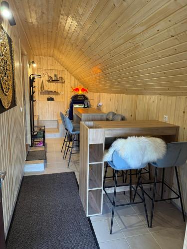 a room with a bar with chairs and a wooden ceiling at Mountain Mia in Šišava