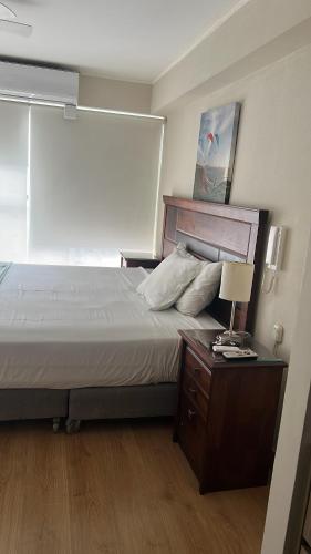 a bedroom with a bed and a night stand with a lamp at Urbano Apartments in Lima