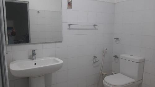 a white bathroom with a sink and a toilet at Pearl of Kandy in Kandy