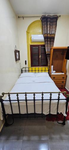 a bedroom with a large bed and a wooden dresser at Ryad 91 in Casablanca