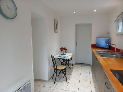 a kitchen with a table and chairs and a clock at Appartement avec jardin in Adé