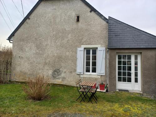 a table and chairs in front of a house at Appartement avec jardin in Adé