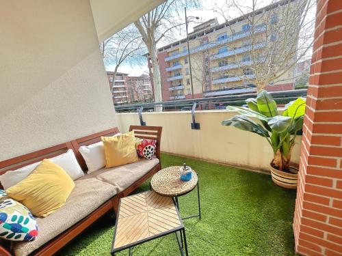 un salon avec un canapé sur un balcon dans l'établissement Les Terrasses du Zenith - Parking - Tramway - Wifi, à Toulouse