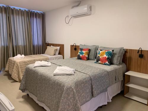 two beds in a hotel room with towels on them at Hotel Formosa - Posto da Mata in Pasto da Mata