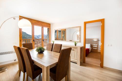 a dining room with a table and a bedroom at Apartaments Les Terrasses del Tarter in El Tarter