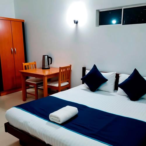 1 dormitorio con cama y mesa con cafetera en Nilmini Haven, en Madampe