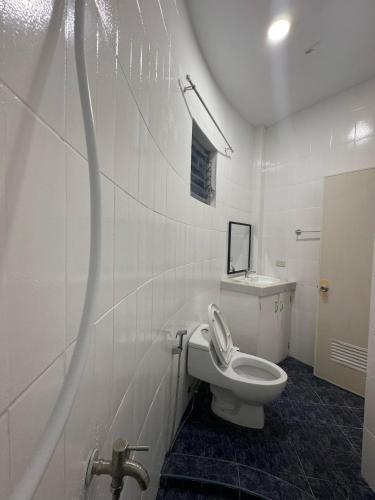 a white bathroom with a toilet and a sink at Stay Inn 3 Boracay in Boracay