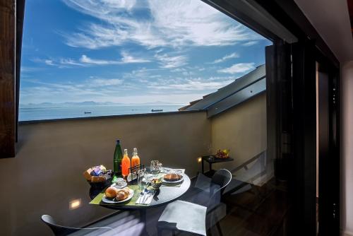 a table on a balcony with a view of the ocean at Kemì Luxury Suites in Vietri sul Mare