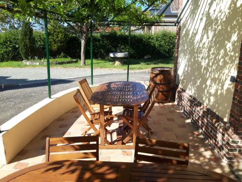a wooden table and chairs on a patio at Hôtel de la Risle in Ambenay