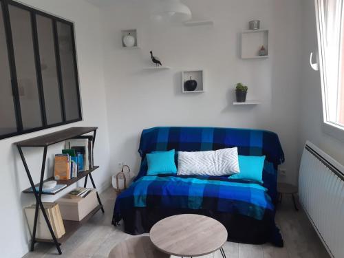 - une chambre avec un lit bleu et une table dans l'établissement Studio Trocadero 2p coté jardin, à Rosny-sous-Bois