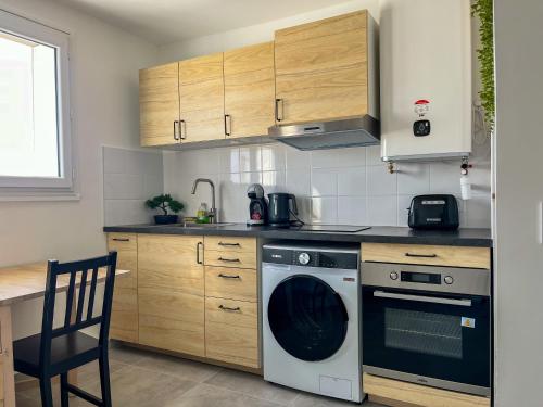 Il comprend une cuisine équipée d'un lave-vaisselle, d'une cuisinière et de placards. dans l'établissement Le Céleste, à Villeurbanne