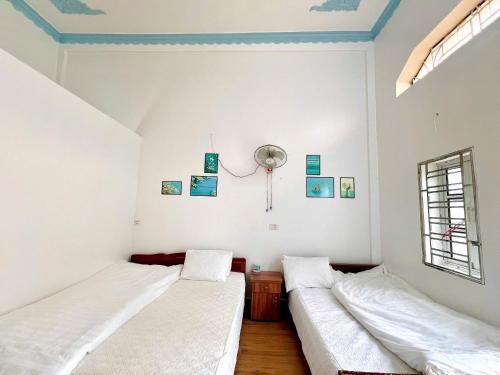 two beds in a room with white walls and blue ceilings at Tuấn huyền vlog homestay in Mộc Châu