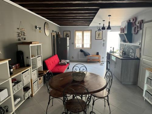 a living room with a table and chairs and a kitchen at Gîte du fief in Cires-lès-Mello