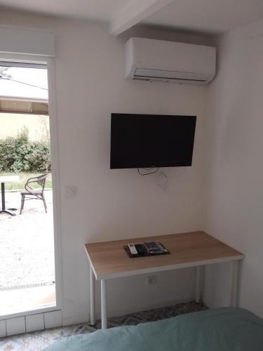 Cette chambre dispose d'une télévision murale et d'une table. dans l'établissement Le passé temps, à Éguilles