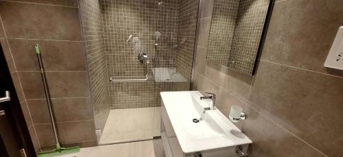 a bathroom with a sink and a shower at Wateera Jebel Sifah in As Sīfah