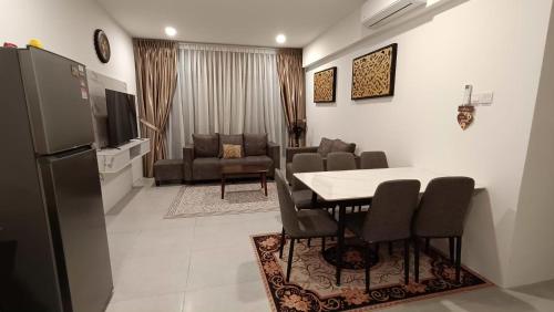 a kitchen and dining room with a table and chairs at Appartment Homestay Kota Samarahan in Kota Samarahan