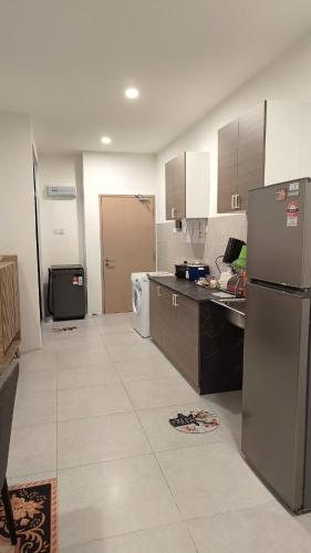 a kitchen with a refrigerator and a counter top at Appartment Homestay Kota Samarahan in Kota Samarahan