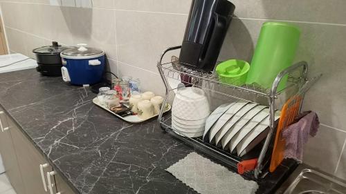 a kitchen counter with a rack with dishes on it at Appartment Homestay Kota Samarahan in Kota Samarahan