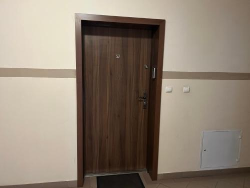 a wooden door in a room with a wall at Kawalerka Kościuszki z parkingiem in Ostrów Wielkopolski