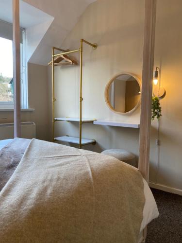 a bedroom with a bed with a mirror and a shelf at Bowness Bay View in Windermere