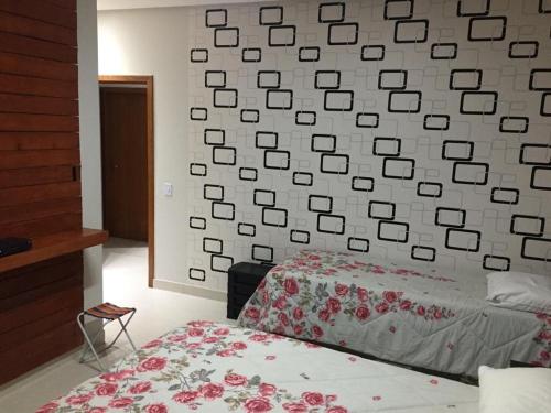 a bedroom with a wall covered in pictures on the wall at Alcobaça Beach House in Alcobaça