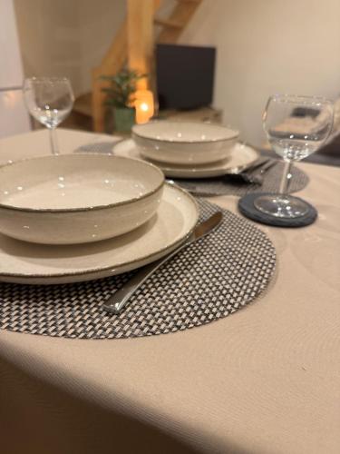 - une table avec des assiettes et des verres à vin dans l'établissement T2 à Saint-Aygulf, à Saint-Aygulf