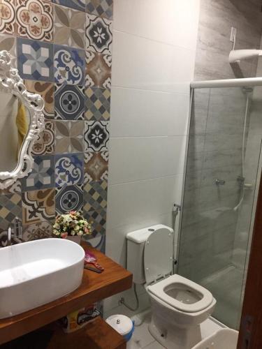 a bathroom with a toilet and a sink and a shower at Alcobaça Beach House in Alcobaça