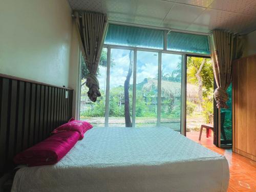 a bedroom with a large bed with a large window at Tuấn huyền vlog homestay in Mộc Châu