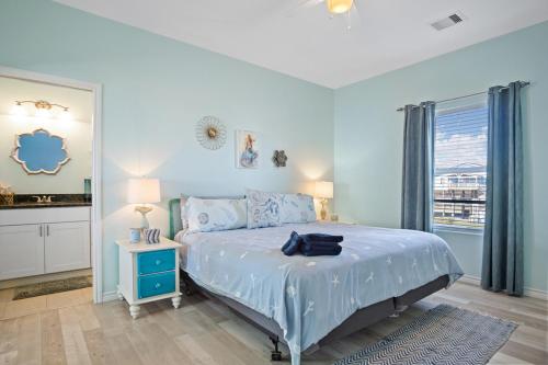 a blue bedroom with a bed and a window at Splash Spacious 3BD 3bath Beachfront! Steps to Beach! in Gilchrist