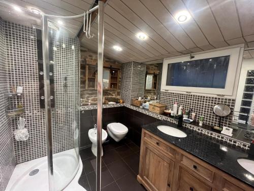 a bathroom with two sinks and a shower and a toilet at Maison de charme avec vue exceptionnelle in Monteils