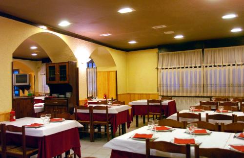 un restaurante con mesas y sillas con manteles rojos y blancos en Hostal Les Collades, en Sort