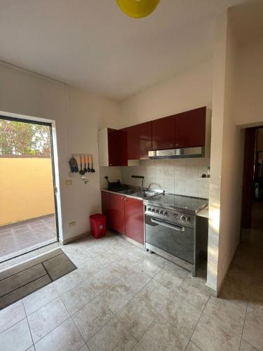 a kitchen with red cabinets and a stainless steel stove at Anna e Gaetano in Misterbianco