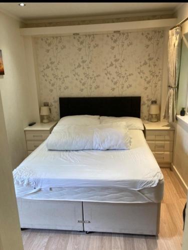 a bedroom with a white bed with two night stands at Rockley Park Private Holiday Homes in Poole