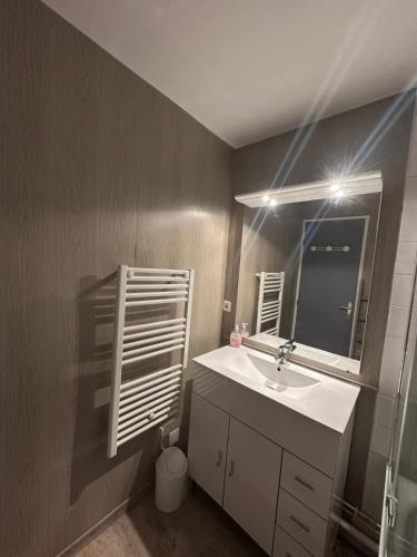 une salle de bain avec un lavabo et un miroir dans l'établissement Charmant appartement, à Les Deux Alpes
