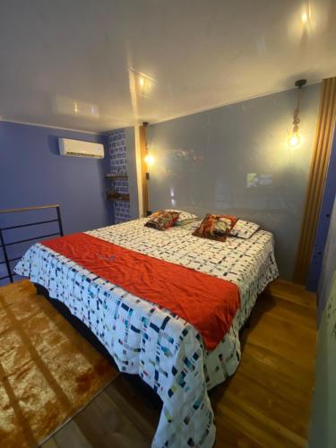 a bedroom with a bed with a red and white blanket at Habitación tipo loft turistico in Mariquita