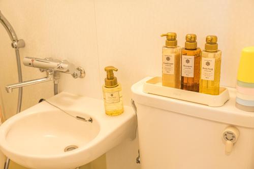 a bathroom with four bottles on the back of a toilet at 和の宿ホテルYamatoinn Akihabara#301 in Tokyo