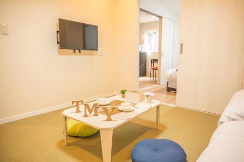 a living room with a table and a tv at 和の宿ホテルYamatoinn Akihabara#301 in Tokyo