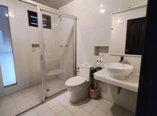 a bathroom with a shower and a toilet and a sink at Hotel Jardines del Carmen in San Cristóbal de Las Casas