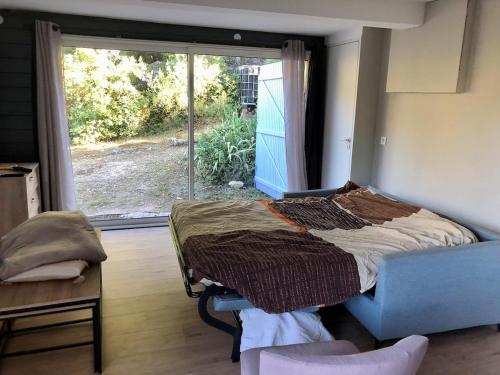 une chambre avec un lit et une grande fenêtre dans l'établissement Nice studio surrounded by nature!, à Grasse