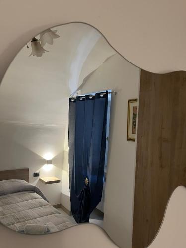 a bedroom with a bed and a blue curtain at La Minicasa in Pacentro