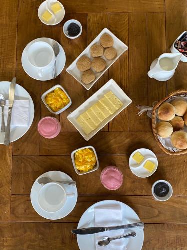 Una mesa cubierta con platos blancos y cuencos de comida. en Hotel Boutique La Casa de Coco, en Gorbea