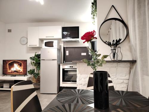 - une cuisine avec une table et un vase avec une fleur dans l'établissement Le Parmentier - Charmant T2, à Clermont-Ferrand