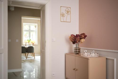 a room with a vase of flowers on top of a cabinet at Apartamenty Centrum Sobieski in Wałbrzych