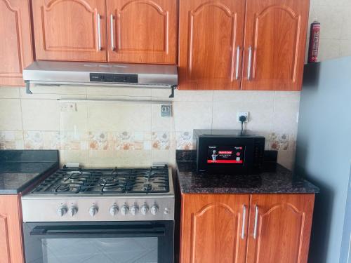 a kitchen with a stove and wooden cabinets at Ocean View Luxurious Homes in Ajman 
