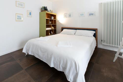a bedroom with a large white bed with white sheets at Ai Priori in Gemona del Friuli