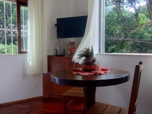 Una pequeña mesa en una habitación con ventana en Apartamento aconchegante na serra!, en Miguel Pereira