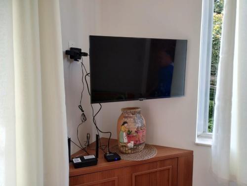 Un televisor de pantalla plana en la pared de una habitación. en Apartamento aconchegante na serra!, en Miguel Pereira