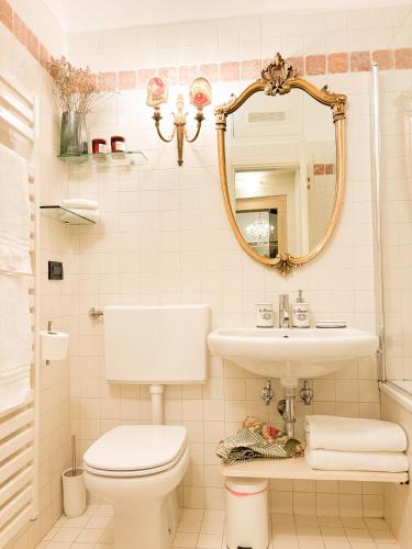 a bathroom with a toilet and a sink and a mirror at Palazzo Tiolo in Verona