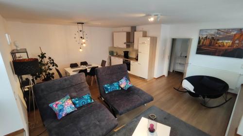 a living room with two couches and a table at Wohnung in Mülheim-Kärlich in Mülheim-Kärlich